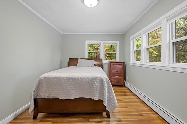 bedroom with light wood-type flooring, a baseboard radiator, and crown molding