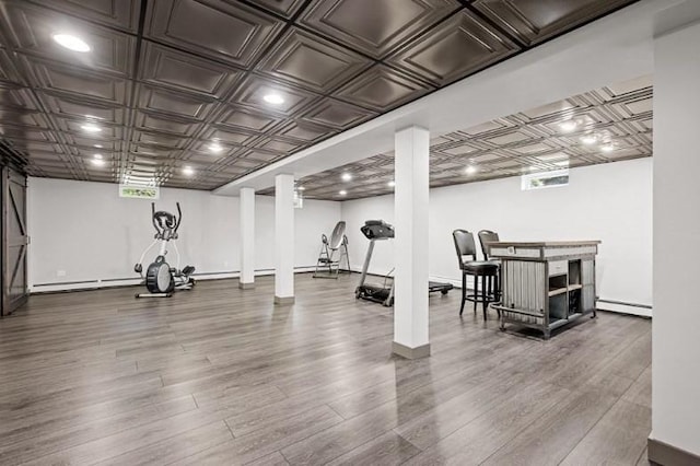 workout room with hardwood / wood-style floors and baseboard heating