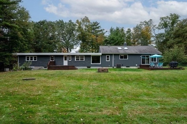 back of house featuring central air condition unit, a wooden deck, and a lawn