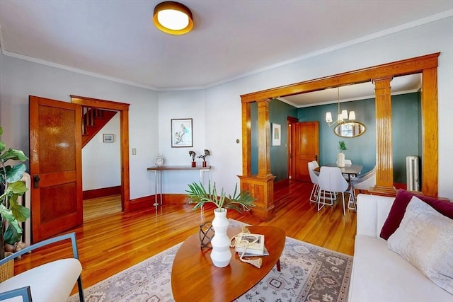 living area featuring ornamental molding, radiator heating unit, wood finished floors, and ornate columns