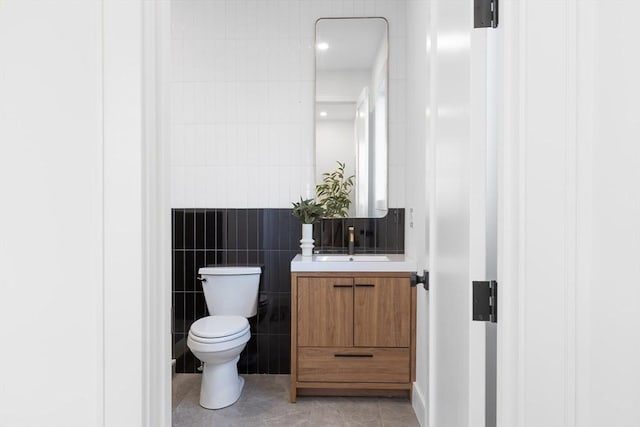 bathroom with vanity, tile walls, toilet, and tile patterned floors