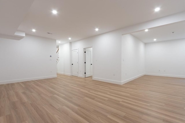 finished below grade area with recessed lighting, light wood-style flooring, and baseboards