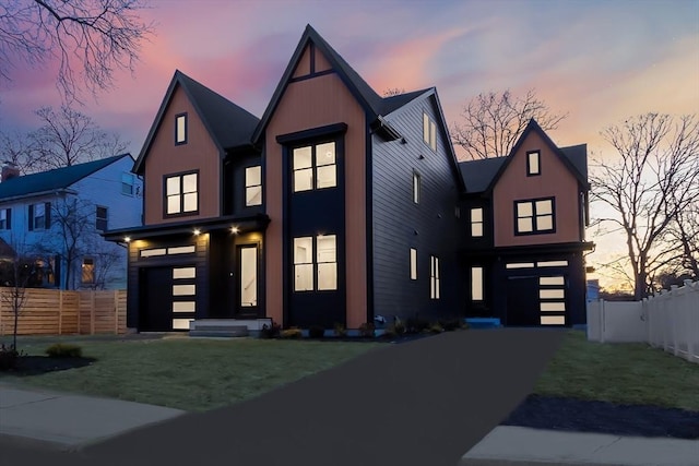 view of front of home with a garage, driveway, and fence