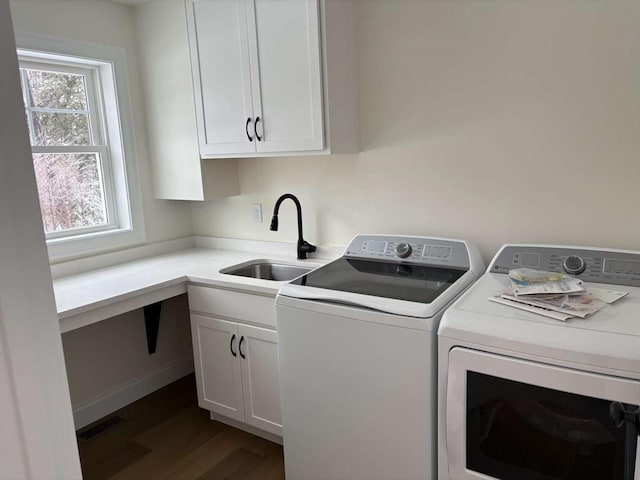 laundry area with a sink, visible vents, washer and dryer, cabinet space, and dark wood-style floors