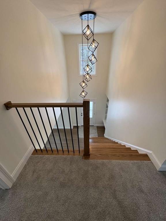 stairway featuring carpet and baseboards