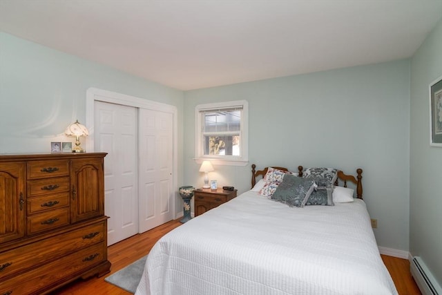 bedroom featuring light hardwood / wood-style floors, a closet, and a baseboard radiator