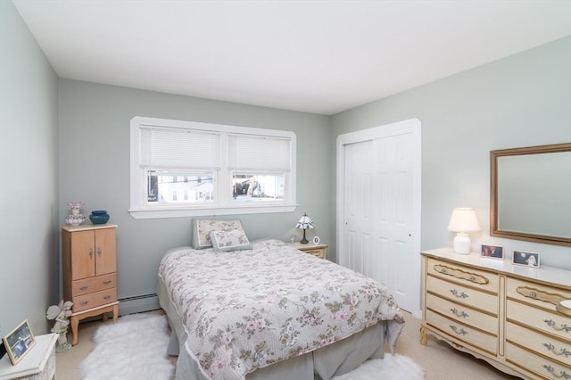 bedroom featuring light carpet, a closet, and a baseboard radiator