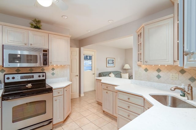 kitchen featuring sink, light tile patterned flooring, decorative backsplash, and appliances with stainless steel finishes