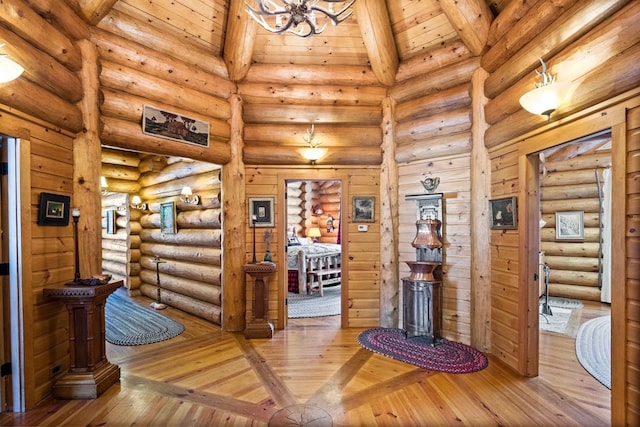 interior space featuring light hardwood / wood-style flooring, beam ceiling, log walls, and wooden ceiling