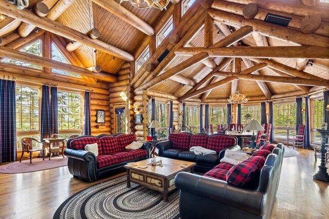 sunroom / solarium with lofted ceiling with beams, a chandelier, and a healthy amount of sunlight