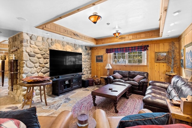 living room featuring wooden walls and a tray ceiling