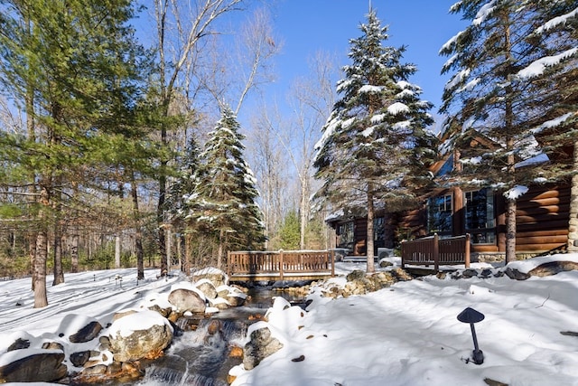 yard layered in snow featuring a wooden deck