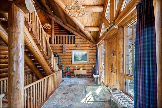 interior space with rustic walls, wood ceiling, a chandelier, and a high ceiling