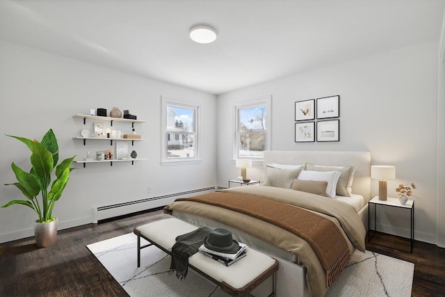 bedroom with dark hardwood / wood-style flooring and a baseboard heating unit