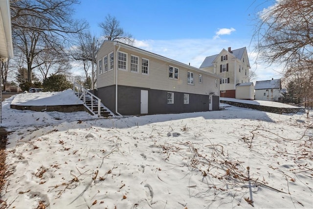 view of snow covered back of property