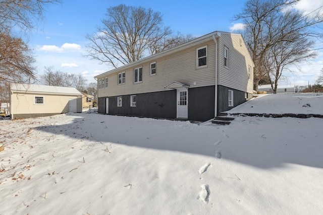 snow covered property with a storage shed