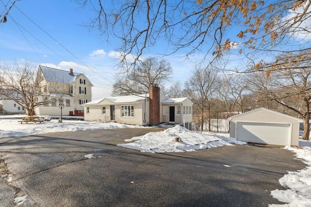 view of front of home featuring a garage and an outbuilding