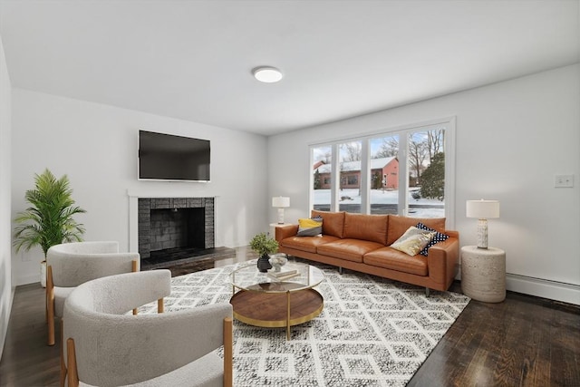 living room featuring a baseboard radiator, wood-type flooring, and a fireplace