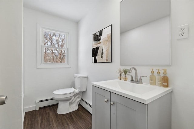 bathroom featuring wood-type flooring, a baseboard heating unit, vanity, and toilet