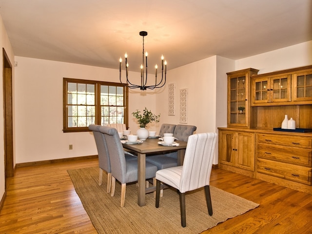 dining space featuring light hardwood / wood-style flooring and a notable chandelier