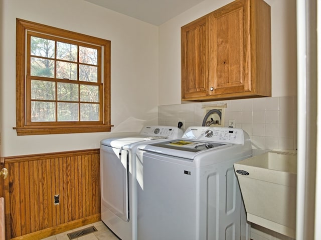 laundry area featuring washer and dryer, cabinets, light tile patterned floors, and sink