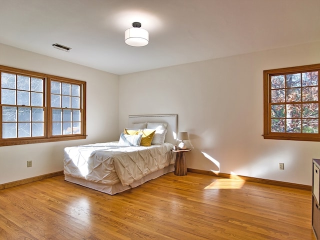 bedroom featuring light hardwood / wood-style floors and multiple windows