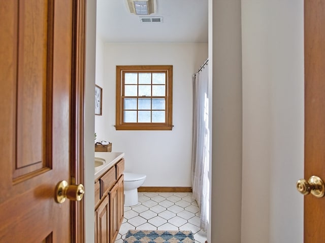 bathroom featuring tile patterned floors, vanity, and toilet