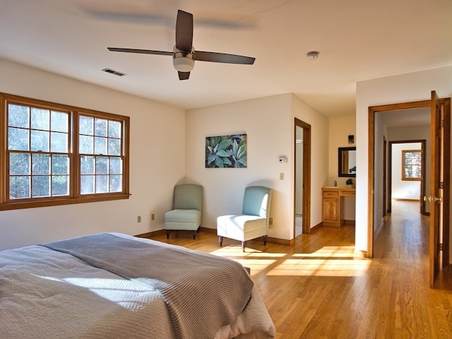 bedroom featuring ensuite bath, ceiling fan, and light hardwood / wood-style floors