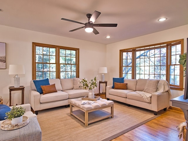 living room with light hardwood / wood-style flooring and ceiling fan