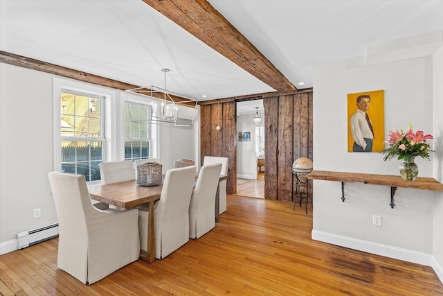 dining space featuring beam ceiling, a notable chandelier, light wood-style flooring, a baseboard heating unit, and baseboards