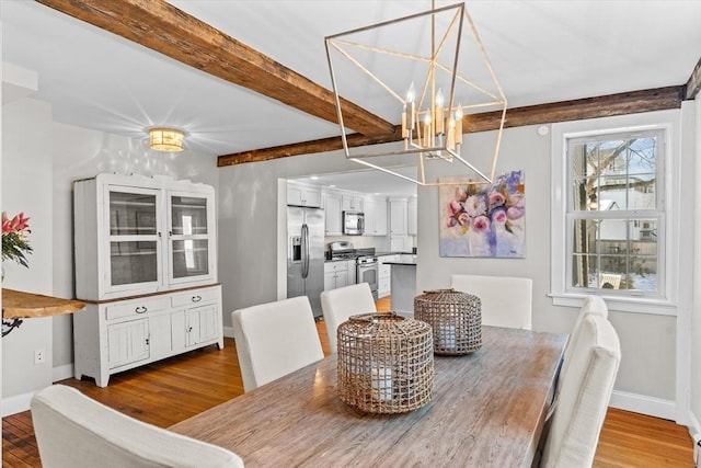 dining area featuring light wood-style floors, baseboards, beamed ceiling, and an inviting chandelier