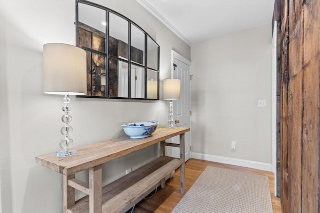 interior space with ornamental molding, baseboards, and wood finished floors