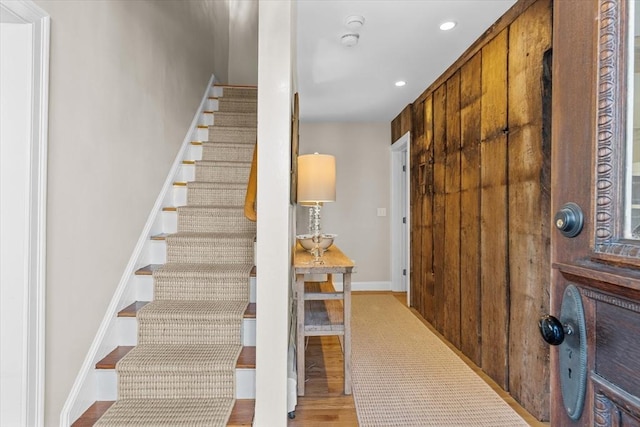 stairway featuring recessed lighting, wood finished floors, and baseboards