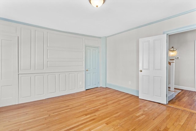 unfurnished bedroom featuring light wood-style floors, baseboards, and a closet