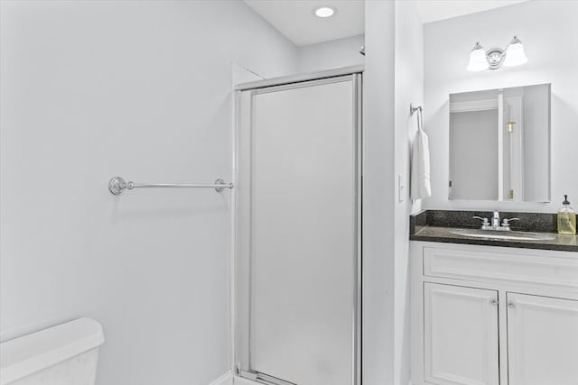 full bathroom featuring a stall shower, vanity, and toilet