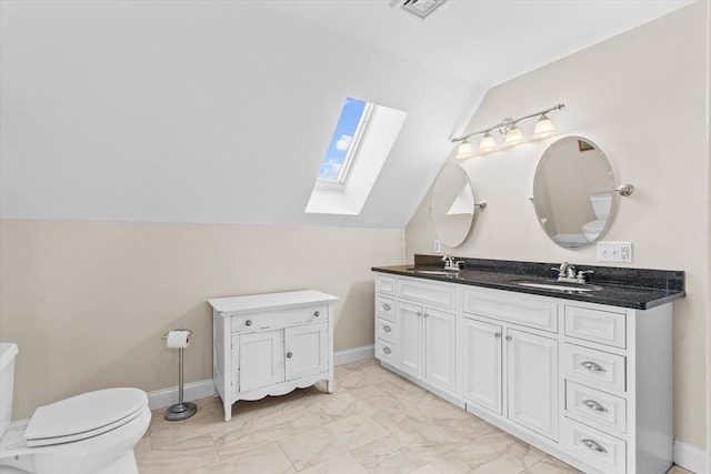 full bath featuring marble finish floor, double vanity, vaulted ceiling with skylight, and a sink