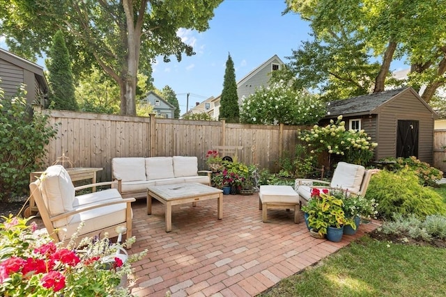 view of patio featuring an outbuilding, a fenced backyard, and an outdoor living space