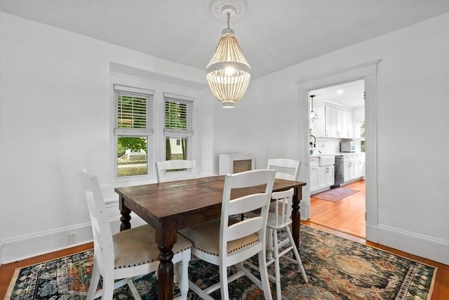 121 W St, Braintree, MA 02184 - dining area with a chandelier, wood finished floors, and baseboards
