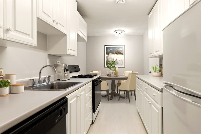 kitchen featuring black dishwasher, white cabinets, stainless steel refrigerator, and white range with gas cooktop