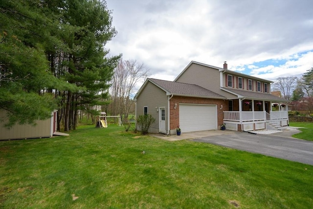 view of property exterior featuring an attached garage, a porch, a chimney, a yard, and driveway