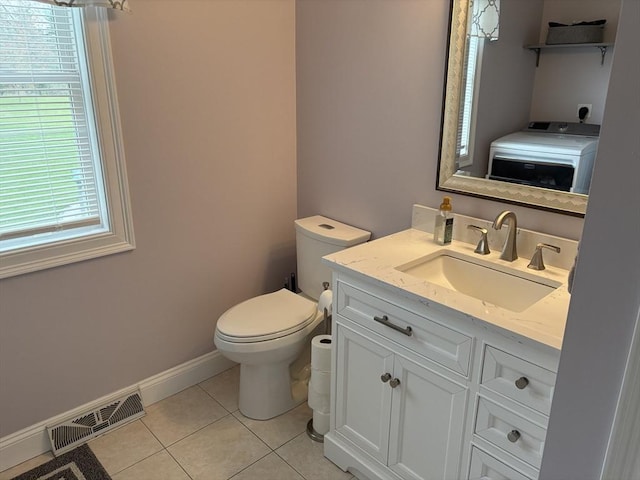 half bath with vanity, toilet, tile patterned floors, washer / clothes dryer, and visible vents