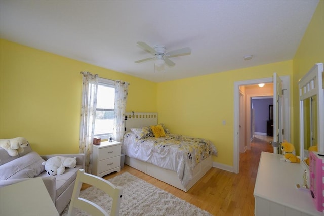 bedroom featuring light wood-style floors, baseboards, and ceiling fan