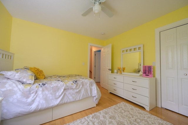 bedroom featuring light wood-type flooring, a ceiling fan, and a closet