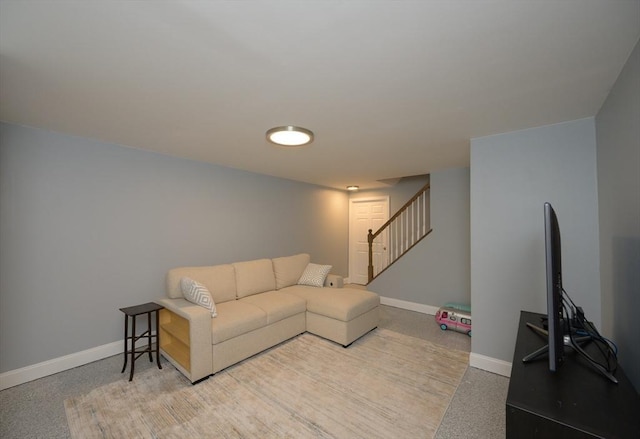 living area with baseboards, light speckled floor, and stairway