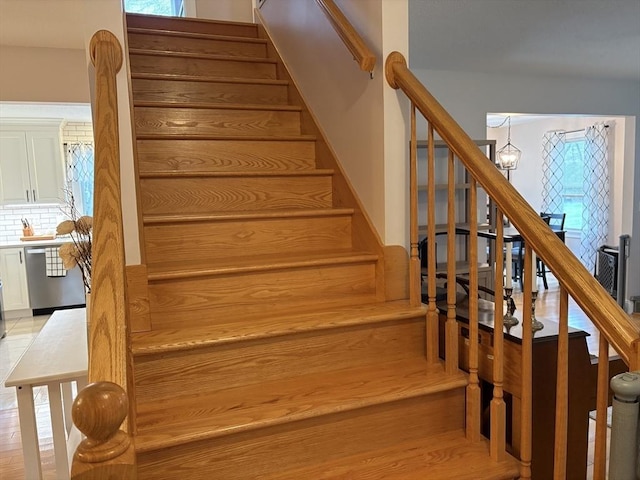 stairs with a chandelier