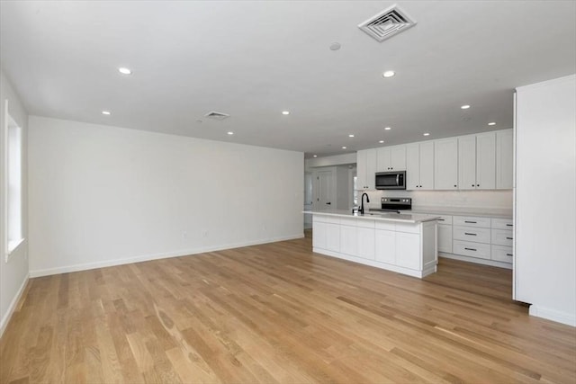106 Broadway, Salem, MA 01970 - kitchen featuring appliances with stainless steel finishes, open floor plan, recessed lighting, light countertops, and light wood finished floors