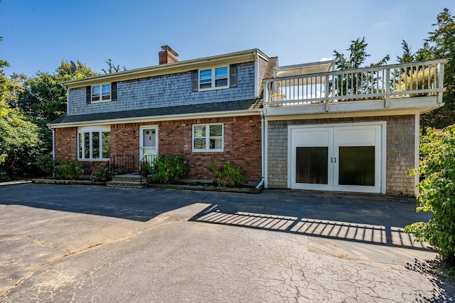 view of front of home featuring a balcony and french doors