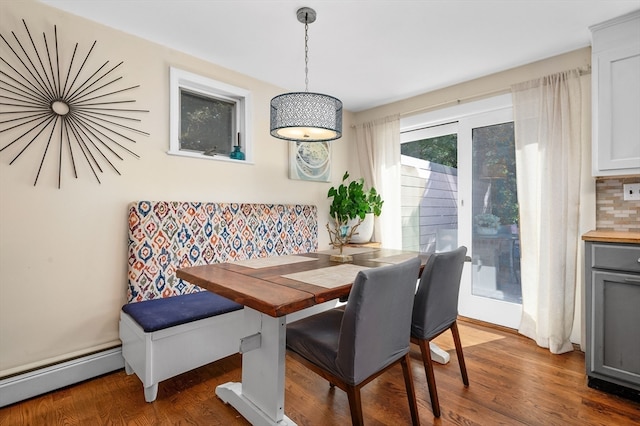 dining room with dark hardwood / wood-style floors and a baseboard heating unit