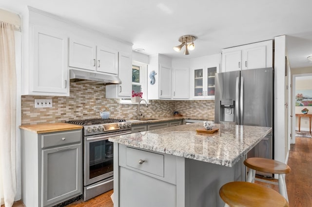 kitchen with light hardwood / wood-style flooring, gray cabinetry, stainless steel appliances, a center island, and white cabinets