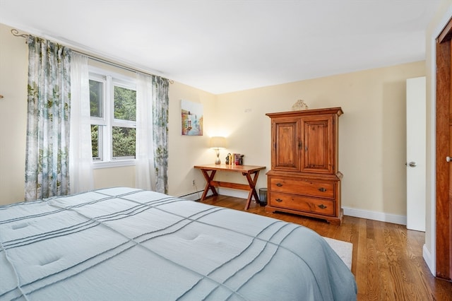 bedroom featuring hardwood / wood-style flooring and a baseboard radiator